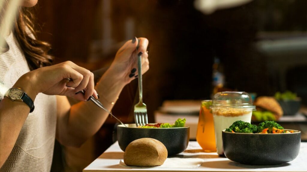 Woman eating food with fork and knife